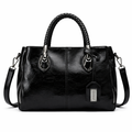 Black leather handbag with braided handles on a white background