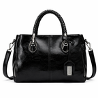 Black leather handbag with braided handles on a white background